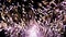 Futuristic fireworks on a background of smoke. Fireworks with particles and sparks in the black night sky close-up. Slow motion.