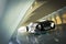 Futuristic luxury sports car hovering at high speeds through a modern interior tunnel .
