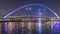 Futuristic Pedestrian Bridge over the Dubai Water Canal Illuminated at Night timelapse, UAE.