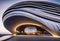 A futuristic striking architectural masterpiece, a concrete building with multiple waves, set in a modern urban landscape