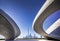 A futuristic striking architectural masterpiece, a concrete building with multiple waves, set in a modern urban landscape