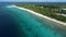 Fuvahmulah island in Maldives and ocean coastline with tropical beach on sunny day. Aerial view