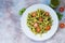 Fuzzily Italian pasta with pesto on light concrete background.