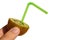 Fuzzy kiwifruit Actinidia Deliciosa sliced in a half with green wet plastic straw held in right hand, white background