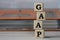 GAAP - acronym on wooden cubes on the background of a folder with documents