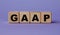 GAAP - acronym on wooden cubes on a lilac background