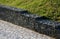 Gabion granite wall. wire baskets filled with stones. on the edge of the sidewalk, in the bend of the path, there is a low wall se