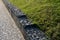 Gabion granite wall. wire baskets filled with stones. on the edge of the sidewalk, in the bend of the path, there is a low wall se