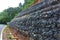 Gabion wall made of stones in the steel mesh, used as a fence on a slope for protection landslide