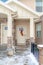 Gabled home entrance with snowy wet steps leading to the glass paned front door