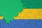 Gabon flag is depicted on a completed jigsaw puzzle with free green copy space on the left side