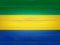 Gabon flag painted on old wood plank background. Brushed wooden board texture. Wooden texture background flag of Gabon.