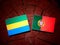 Gabon flag with Portuguese flag on a tree stump isolated