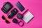 Gadgets and accessories layout on a pink background. Photographic equipment, purse with dollars, smart clock, smartphone, notebook