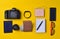 Gadgets and accessories layout on a yellow background. Power bank, photographic equipment, purse with dollars, smart clock