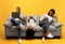 Gadgets addiction. Young black family of three using different electronic devices, sitting on sofa on yellow background