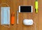 Gadgets, a white computer keyboard and stationery next to a hand sanitizer and protective medical mask on a wooden