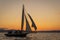 gaff-rigged sloop at sunset