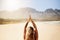 Gain control of your mind and liberate yourself. Rearview shot of a young woman practising yoga on the beach.
