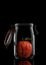 A Gala Apple inside a glass storage or canning jar isolated on black with reflection, with lid open