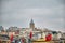 Galata tower during rainy day and overcast weather. Many turkish flag and huge cloudy sky.