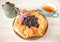 Galeta galette tart cake pie of whole grain flour with blueberries on a white country table with Turquoise color cup with flowers