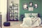 Gallery of black and white poster on green wall behind king size bed with pillows and blanket