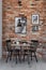 Gallery of black and white posters on brick wall of small dining room interior with table and black chair