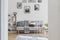 Gallery of black and white posters on the wall of classy living room interior