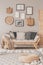 Gallery of black and white posters and wicker accessories on beige wall of Scandinavian living room