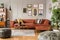 Gallery of posters in elegant grey living room interior with brown corner sofa