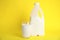 Gallon bottle and glass of milk on yellow background