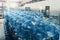 Gallons or plastic bottles of purified drinking water on pallets in water production factory interior inside