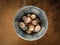 Galvanized pail of chicken eggs sits on dirt.