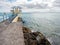 Galway / Ireland 02/20/2019 Blackrock public diving board, Boy jumping into water. High tide, Cloudy sky, Burren mountains in the