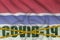 Gambia flag and Covid-19 inscription with orange quarantine border tape. Coronavirus or 2019-nCov virus concept