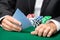 Gambler playing cards with poker chips on the table