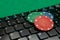 Gambling chips on computer keyboard on green background