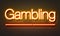 Gambling neon sign on brick wall background.