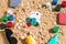 Gambling on vacation concept - white sand with seashells , colored poker chips and cards. Top view