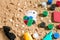 Gambling on vacation concept - white sand with seashells , colored poker chips and cards. Top view