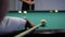 Game of billiards. Close-up of a player hitting a cue in a billiard ball.