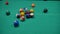 game of billiards with colored and numbered balls. 8 ball. green table and moving balls with billiard cue. panning the