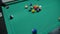 game of billiards with colored and numbered balls. 8 ball. green table and moving balls with billiard cue. panning the