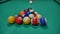 game of billiards with colored and numbered balls. 8 ball. green table and moving balls with billiard cue. panning the