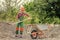 Game of builder and construction. Outdoor activity concept. girl who is transporting rubble in a wheelbarrow