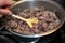 Game goulash in pot with stirring spoon