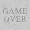 Game over letters carved on stone plate. Chips on rock