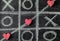 Game of Tic-tac-toe with crossed line and small hearts on blackboard