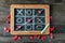 Game of Tic-tac-toe with crossed line and small hearts on blackboard, top view